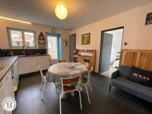 eine Küche und ein Wohnzimmer mit einem Tisch und einer Couch in der Unterkunft Maison climatisée proche plage à Saint-Hilaire-de-Riez - FR-1-426-591 in Saint-Hilaire-de-Riez