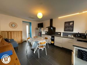 eine Küche und ein Esszimmer mit Tisch und Stühlen in der Unterkunft Maison climatisée proche plage à Saint-Hilaire-de-Riez - FR-1-426-591 in Saint-Hilaire-de-Riez