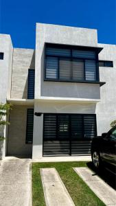 Nuevo NayaritにあるEspectacular casa nuevo Nayatitの前に車が駐車されている家