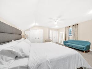 une chambre avec un lit blanc et une chaise bleue dans l'établissement The Splash & Stay Villa, à Belle River 35 autres photos