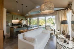 Una sala de estar con un sofá blanco y una cocina. en Villa Ceviche Home at the Heart of Venao, en Playa Venao