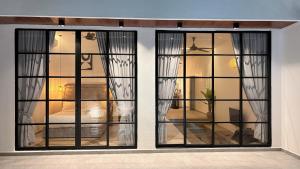 a room with two windows with curtains and a bed at Arouna Villa Private Pool in Dungun