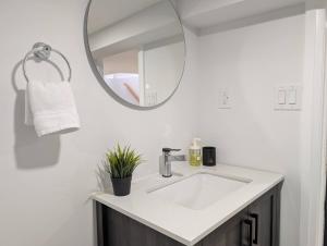ハミルトンにあるThe Urban Hideaway - Stylish Stay - Prime Spotの白い洗面台と鏡のあるバスルーム