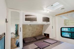 ein Bett in einem kleinen Zimmer in einem Wohnmobil in der Unterkunft 2-bedroom Camper Trailer Cottage #3 in Dillon
