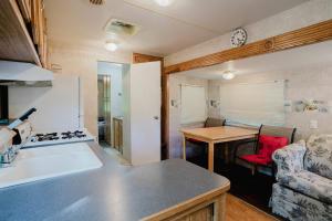 a kitchen and living room with a stove and a counter at 2-bedroom Camper Trailer Cottage #1 in Dillon