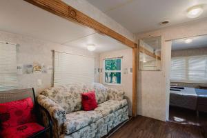 a living room with a couch with red pillows at 2-bedroom Camper Trailer Cottage #1 in Dillon