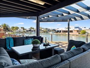 a patio with couches and a table and a view of the water at Private Jetty -family & Pet Friendly in Mandurah