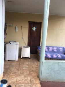 a room with a porch with a purple couch and a door at Casa no campos in Foz do Iguaçu