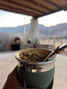 a pot of food sitting on a table with a spoon at Wayra del Cerro in Purmamarca