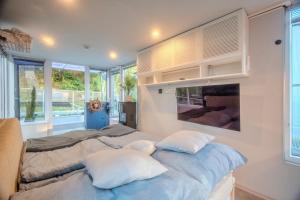 a bedroom with a large bed with white pillows at Houseboat Prague with Paddle Boat -Sail, Explore and Relax in Prague