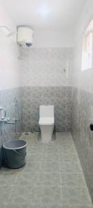 a bathroom with a toilet and a bath tub at Sri Abirami Mahal in Tiruvannāmalai
