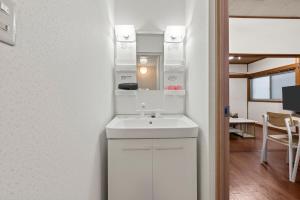 ein Badezimmer mit einem weißen Waschbecken und einem Spiegel in der Unterkunft ゲストハウス奏 Private rental 136平米 5LDK Long-term stays OK in Osaka + 138 Fotos