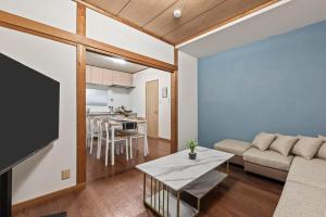 ein Wohnzimmer mit Sofa und Tisch in der Unterkunft ゲストハウス奏 Private rental 136平米 5LDK Long-term stays OK in Osaka