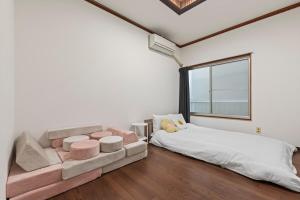 ein Schlafzimmer mit einem Bett und einem großen Fenster in der Unterkunft ゲストハウス奏 Private rental 136平米 5LDK Long-term stays OK in Osaka