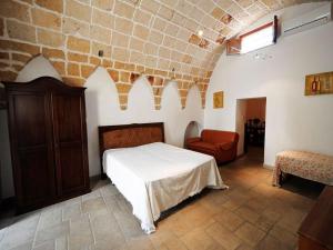 - une chambre avec un lit et une chaise dans l'établissement Anemo, à Corigliano dʼOtranto