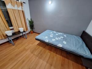 una cama en una habitación con suelo de madera en KTM Homestay, en Katmandú