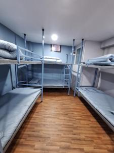 Habitación con 3 literas y suelo de madera. en KTM Homestay, en Katmandú