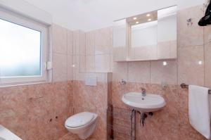a bathroom with a toilet and a sink at White Residence Accommodation in Sukošan