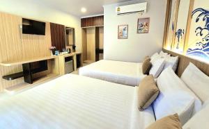 a hotel room with two beds and a television at Diamond Cave Resort in Railay Beach