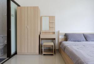 Ka RornにあるStayKa Suitesのベッドと鏡付きの机がある寝室