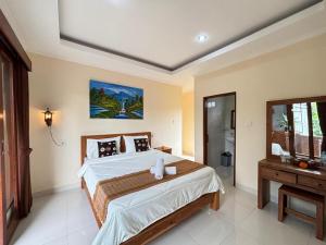 a bedroom with a large bed and a mirror at Wahadi homestay in Ubud