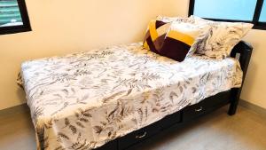 a small bed with a white comforter and pillows at Casa Margen in Ormoc