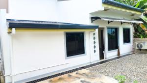 a house with white walls and windows at Casa Margen in Ormoc