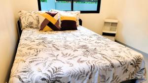 a bed with a white comforter with plants on it at Casa Margen in Ormoc +14 photos