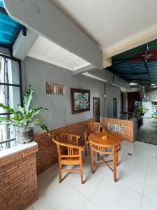 a dining room with a table and chairs and a brick wall at Wahadi homestay in Ubud