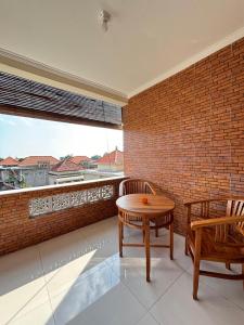 a room with a table and chairs and a brick wall at Wahadi homestay in Ubud