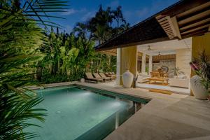 a swimming pool in a backyard with a house at Coral Heaven 4 by Bali Villa Solutions in Badung