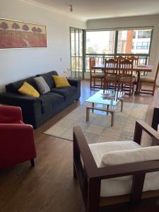 a living room with a couch and a table and chairs at Departamento en Condominio Puerto Pacífico in Viña del Mar