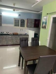 チェンナイにあるTynampet Poes road 2の部屋に木製のテーブルと椅子が置かれたキッチン