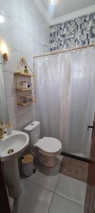 a white bathroom with a toilet and a sink at Casa de praia Lar abençoado! in Cabo Frio +7 photos