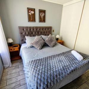 a bedroom with a large bed with a blue blanket at Experiencia 2Terramar 1Hab-1Baño-1 Estac in Antofagasta +8 photos