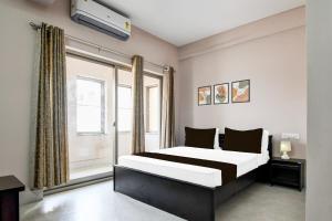 a bedroom with a large bed and a window at Hotel O Aasiyanaa Guest House in Bhubaneshwar