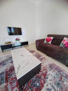 a living room with a couch and a table at Rossa Homestay, Kok Lanas in Kampong Kok Lanas