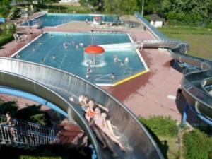 a swimming pool with people in the water at Gästehaus Heidi in Kröv