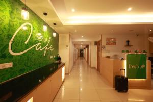 a lobby of a hotel with a hotel cafe sign on the wall at Freshup Hotel in Tirupati