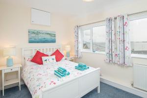 a white bedroom with a bed and two windows at Shell Haven in Narberth +33 photos