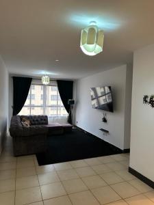 a living room with a couch and a window at The white cottage in Kitengela 