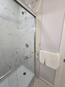 a bathroom with a shower with a glass door at Peaceful Haven in Prime Location in Calgary +12 photos