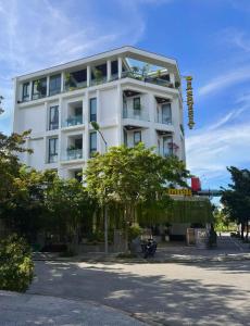 un bâtiment blanc avec un arbre devant lui dans l'établissement D & A Homestay Hue, à Hue
