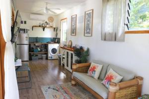 a living room with a couch and a microwave at Amori Cabin in Arorangi