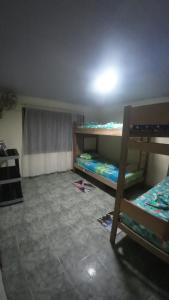 a room with two bunk beds and a tiled floor at Capibara Hostel in Leticia