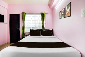 Un dormitorio con una gran cama blanca en una habitación rosa. en SPOT ON Supreme Suites, en kolkata