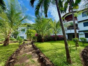 a path in front of a building with palm trees at Silver Residence Apartments by MOKAWA in Malindi