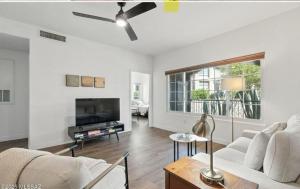 ein Wohnzimmer mit einem weißen Sofa und einem Fernseher in der Unterkunft Catalina Location Peaceful Near Parks in Oro Valley