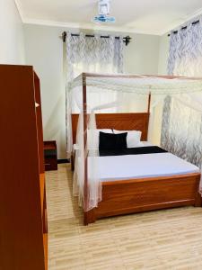 a bedroom with a bed with a wooden frame at Sunset Inn Lodge in Arusha