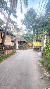 an empty street in a village with trees at Hai Phuong Tuyen Guesthouse in Phu Quoc